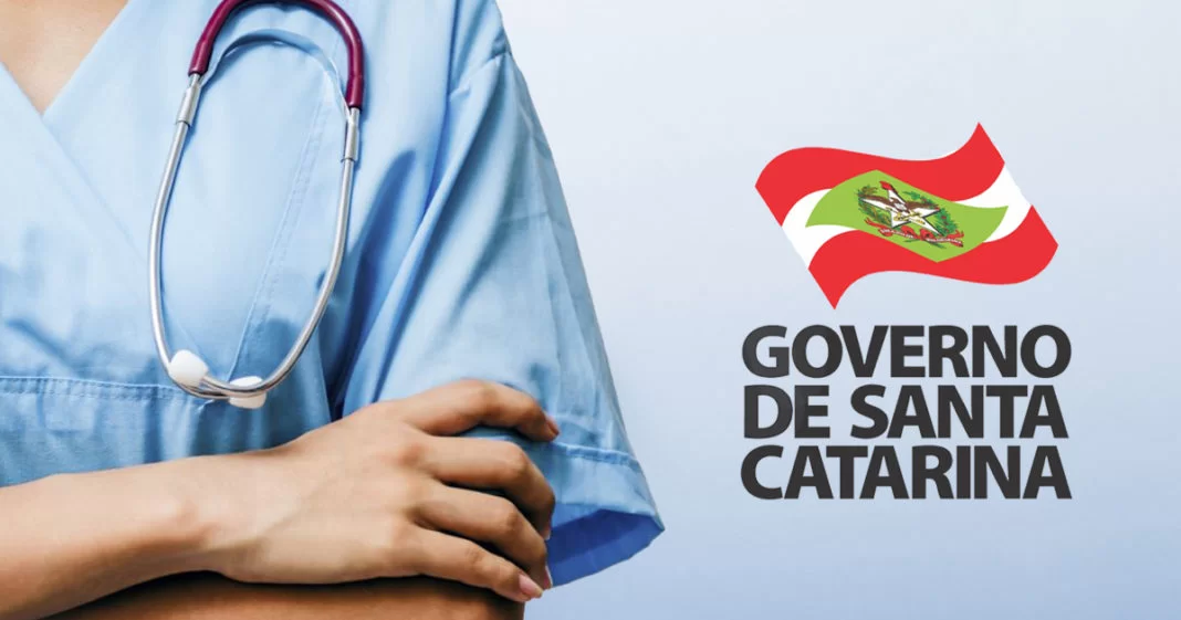 Uma pessoa com uniforme médico e um estetoscópio pendurado no pescoço fica com os braços cruzados. À direita, a bandeira de Santa Catarina e o texto “GOVERNO DE SANTA CATARINA” são visíveis sobre fundo azul claro, destacando 108 oportunidades por meio da SES – processos seletivos de SC.