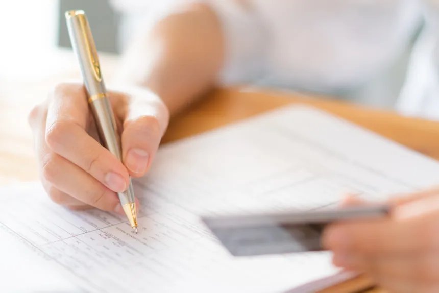 hand with pen credit card application form 1