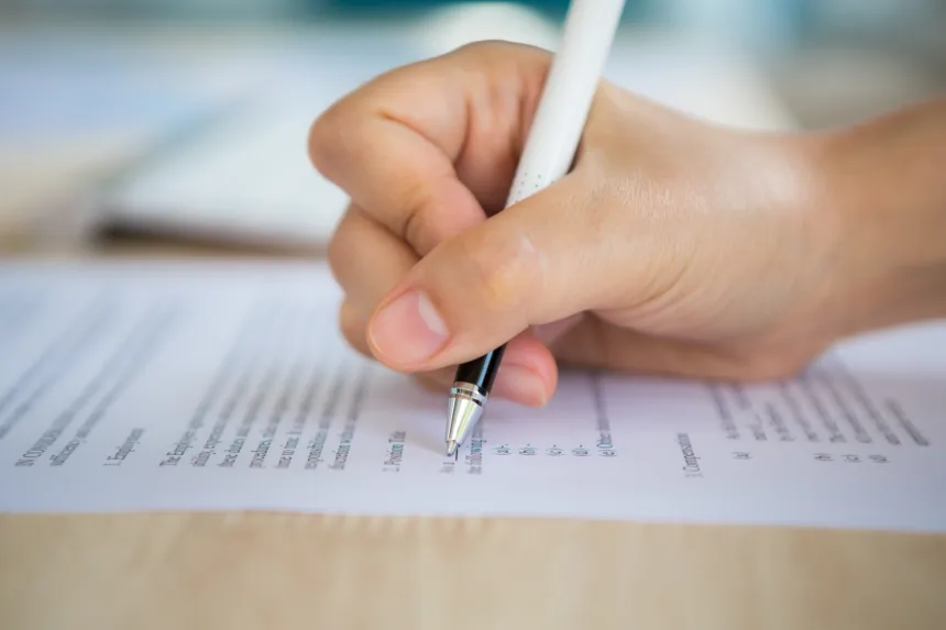 hand with pen writing paper